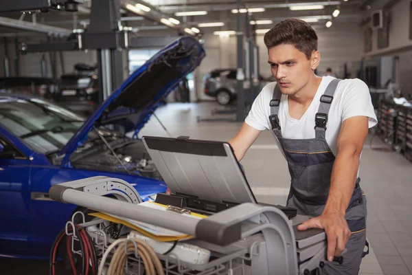 Joven mecánico de coches guapo reparación de vehículos en su garaje —  Fotos de Stock