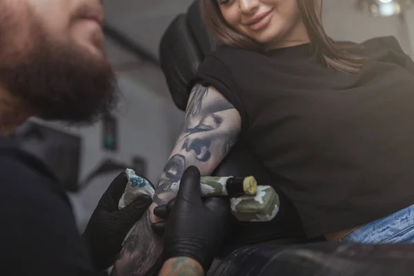 Młoda atrakcyjna kobieta robi nowy tatuaż profesjonalnym tatuażem — Zdjęcie stockowe