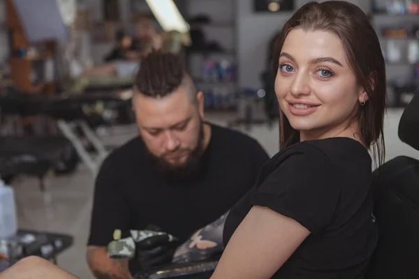 Young attractive woman getting new tattoo by professional tattoo — Stock Photo, Image