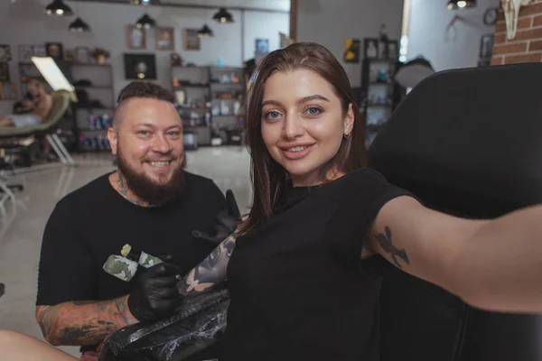 Jovem mulher atraente recebendo nova tatuagem por tatuagem profissional — Fotografia de Stock