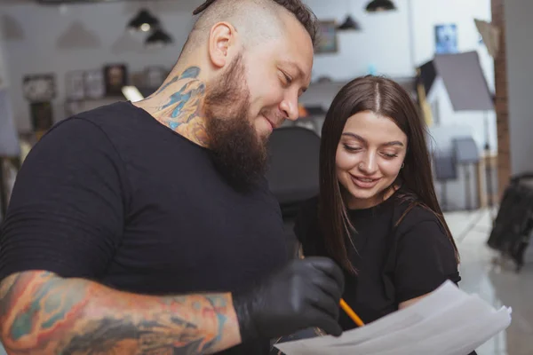 Young attractive woman getting new tattoo by professional tattoo — Stock Photo, Image
