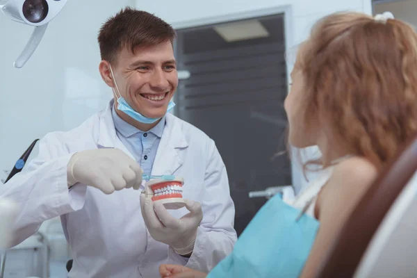 Odontólogo masculino guapo trabajando en su clínica — Foto de Stock