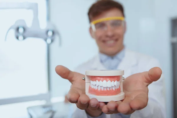 Schöner männlicher Zahnarzt arbeitet in seiner Klinik — Stockfoto