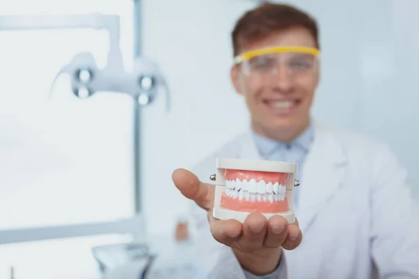 Bello dentista maschio che lavora alla sua clinica — Foto Stock