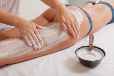 Çekici kadın spa merkezinde maskeyle vücut sargıları alıyor.