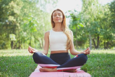 Parkta yoga yapan muhteşem atletik kadın.