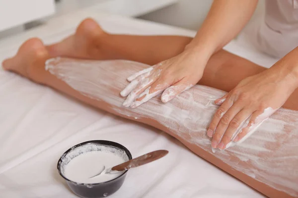 Çekici kadın spa merkezinde maskeyle vücut sargıları alıyor.