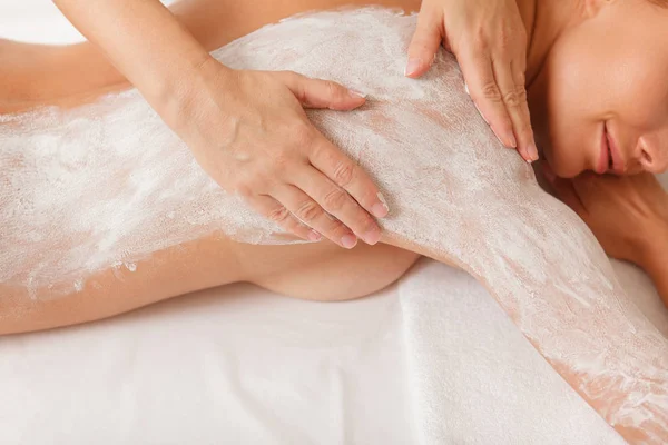 Çekici kadın spa merkezinde maskeyle vücut sargıları alıyor.