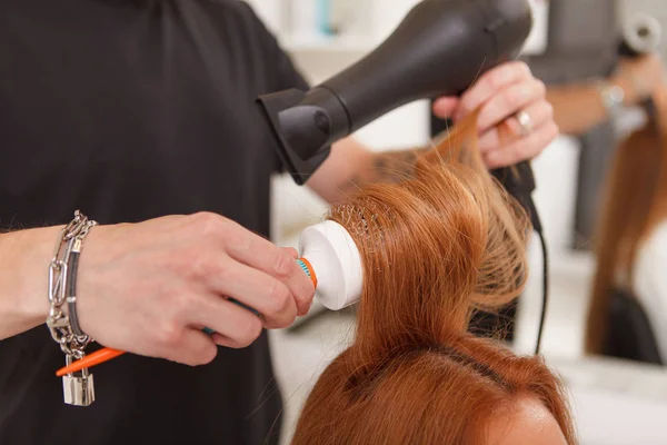 Coiffeur coiffant les cheveux d'une cliente — Photo