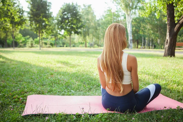 Nádherná atletická žena dělá jógu v parku — Stock fotografie