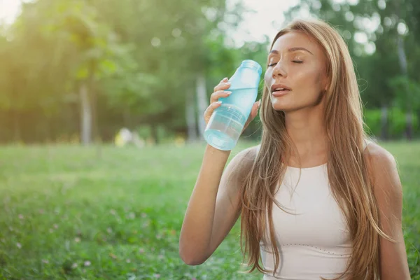 Superbe femme sportive qui boit de l'eau au parc — Photo