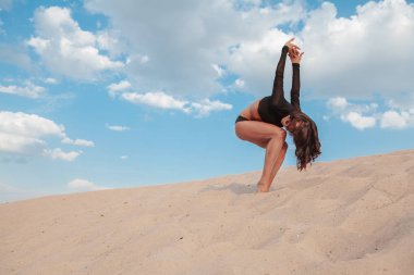 Çölde kumların üzerinde dans eden muhteşem seksi kadın.