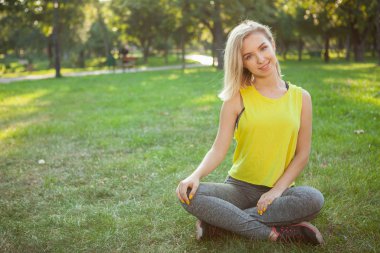 Büyüleyici genç sporcu kadın sabah parkta egzersiz yapıyor.