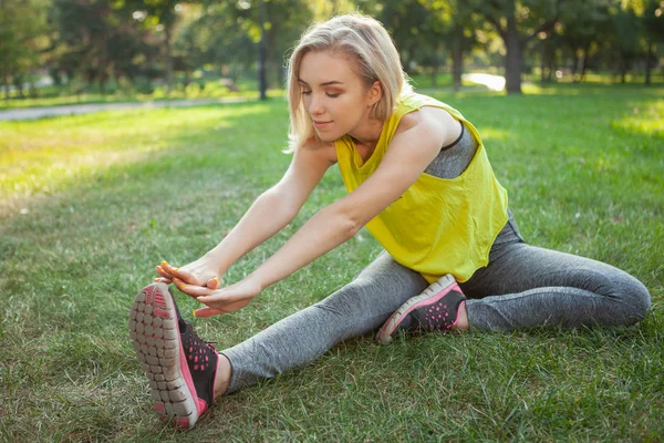 Encantadora joven deportista haciendo ejercicio en el parque por la mañana — Foto de Stock