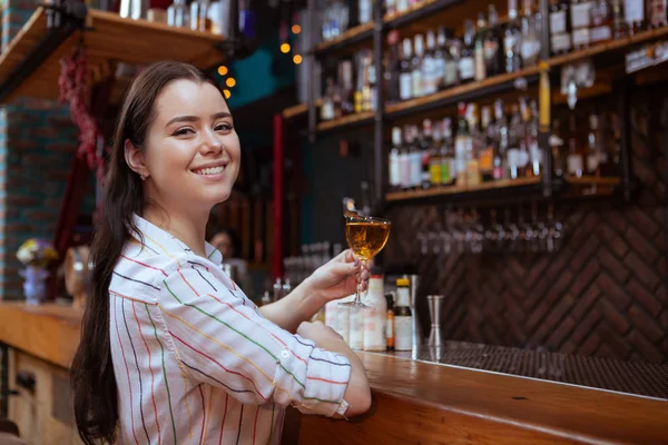 Urocza młoda kobieta pije drinka w barze. — Zdjęcie stockowe