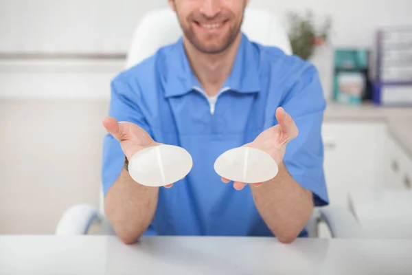 Plastic surgeon showing breast implants to a patient — Stock Photo, Image