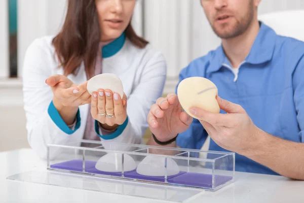 Two plastic surgeons discussing silicone breast implants — Stock Photo, Image