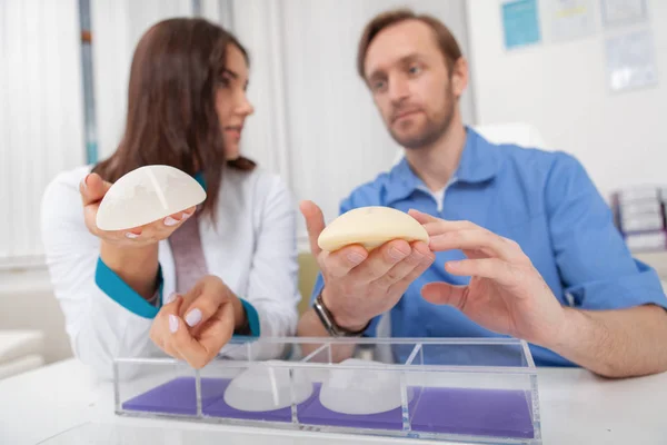 Two plastic surgeons discussing silicone breast implants — Stock Photo, Image