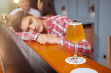 Bira barında içen yakışıklı genç adam.