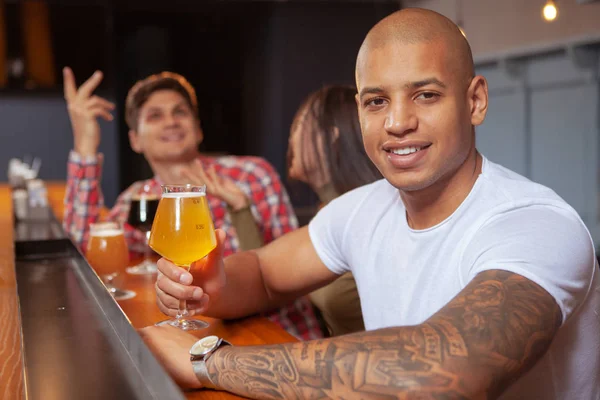 Różnorodna grupa przyjaciół pije razem piwo w pubie. — Zdjęcie stockowe