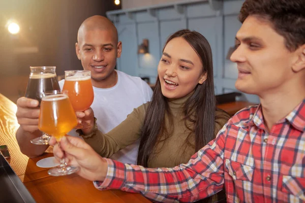 Bunte Gruppe von Freunden trinkt gemeinsam Bier in der Kneipe — Stockfoto