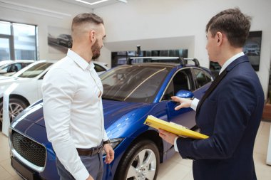 Satıcıdan yeni araba alan yakışıklı bir adam.