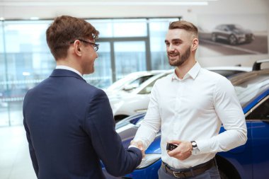 Satıcıdan yeni araba alan yakışıklı bir adam.