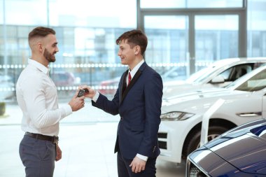 Satıcıdan yeni araba alan yakışıklı bir adam.