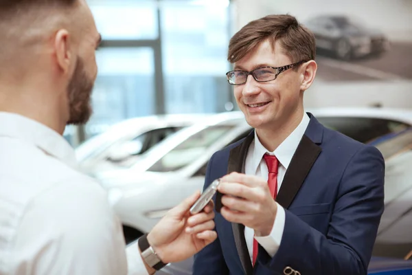 Jóképű férfi új autót vesz a kereskedésben. — Stock Fotó