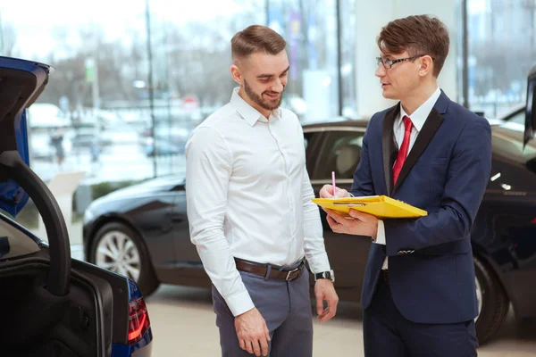 Молодий бізнесмен купує новий автомобіль — стокове фото