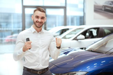 Galeride yeni otomobil seçen yakışıklı bir adam.