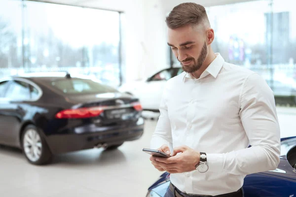 Красивий чоловік вибирає новий автомобіль у дилерському центрі — стокове фото