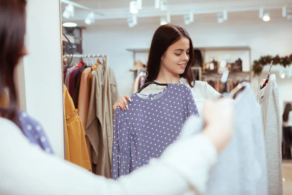 Gyönyörű nő próbál ruha előtt a tükör a boltban — Stock Fotó