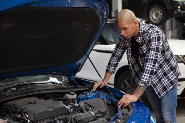 Joven Africano Examinando Motor Coche Deportivo Garaje Mirando Debajo Del —  Fotos de Stock