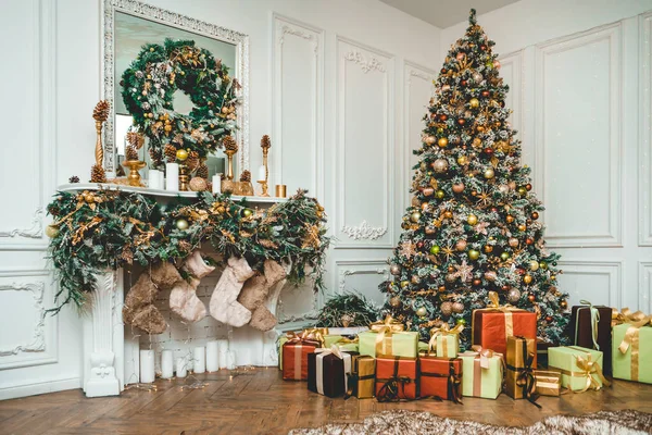 Yeni yıl arifesi oyuncaklarla süslenmiş yeşil ağaçlar hediyelerle süslenmiş.