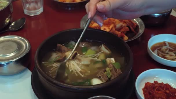 桌上放着用蘑菇和肉盘搅拌的勺子韩式汤 — 图库视频影像