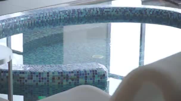Blå Vatten Pool Ett Rum Med Stora Fönster Och Solstolar — Stockvideo