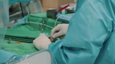 Doktorun hastaya kırmızı ilaç şırıngası verdiği modern tıp ameliyathanesi.