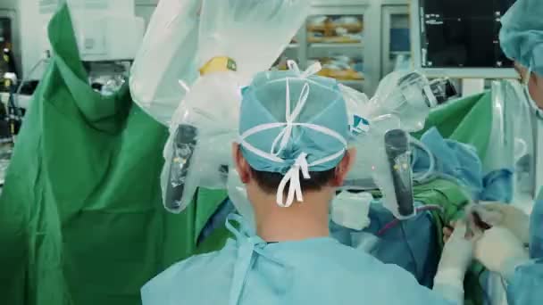 外科医は手術室で電子顕微鏡を通して人体の頭蓋骨の手術を行います — ストック動画