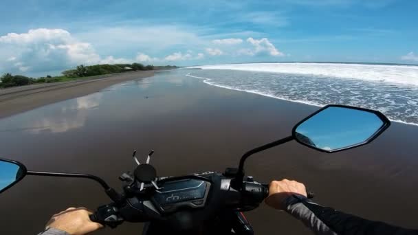 最初の人で海に沿って砂の上にオートバイに乗る — ストック動画