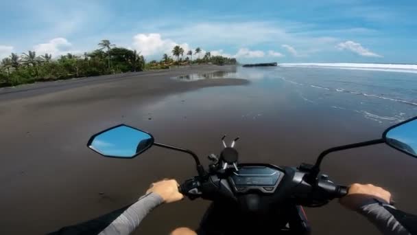 最初の人で海に沿って砂の上にオートバイに乗る — ストック動画