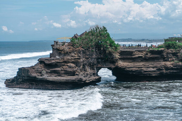 Photo of large waves crashing into large rocks on Nusa Penida island in Indonesia