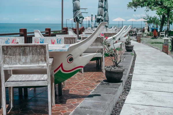 Street cafe with umbrellas, chairs and tables in sea dolphin lead