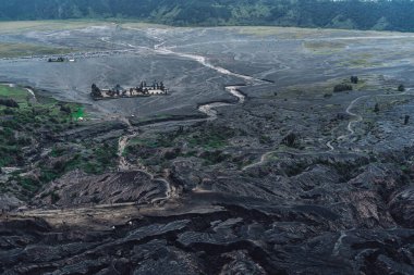 Endonezya 'daki Java adasının arka planında volkanik kaya ve kum tepecikli kayaların fotoğrafı