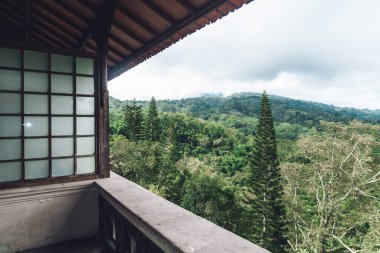 Terk edilmiş, balkonlu, camlı pencereli ve pencereli karanlık bir binanın fotoğrafı.