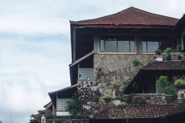 Kirli duvarları ve kırık çatısı olan terk edilmiş bir binanın karanlık fotoğrafı.