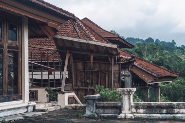 Kırık kırmızı şifre çatılı terk edilmiş bir binanın parlak fotoğrafı.