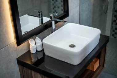 Banyoda seramik lavabo ve ayna fotoğrafı.