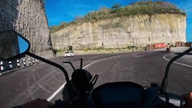 Asfaltlı bir yolda motosiklet sürmek.