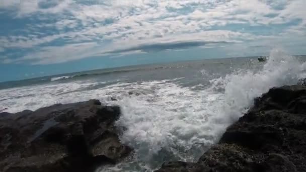 海の見える入り江の上で水吹きに向かって歩いている人のビデオと顔に水の一人称のスプラッシュ — ストック動画